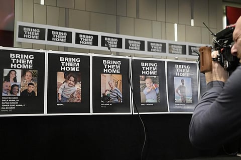 A cameraman films posters with photos of Israeli hostages (Photo | AP)