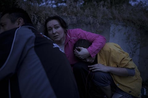 Iryna Sokeryna holds her daughter Liubov Sokeryna as they take cover from Russian shelling while being evacuated from a flooded neighborhood in Kherson (File Photo | AP)
