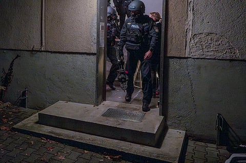 Police officers leave a house during a raid in the early hours of the morning in Munich, Germany, Tuesday, Nov. 21, 2023. (Photo | AP)