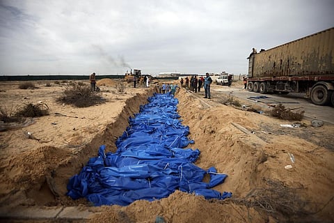 Palestinians bury people killed in the Israeli bombardment who were brought from the Shifa hospital, in a mass grave in the town of Khan Younis, southern Gaza Strip, Nov 22, 2023. (Photo | AP)