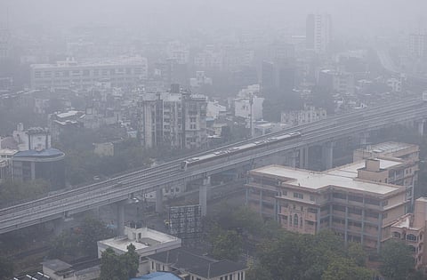 An aerial view of the Gujarat Metro train passing by amid hazy weather conditions after rain, in Ahmedabad, Sunday, Nov. 26, 2023. (Photo | PTI)