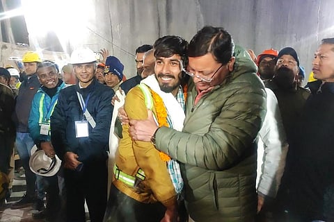 Uttarakhand Chief Minister Pushkar Singh Dhami greets a worker rescued from the site of an under-construction road tunnel that collapsed in Silkyara in Uttarakhand, on Nov 28, 2023. (DIPR)