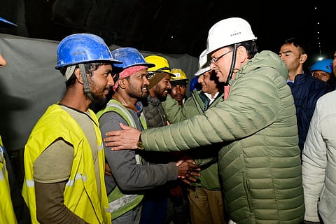Uttarakhand Chief Minister Pushkar Singh Dhami greets the rat-hole miners who successfully rescued the 41 trapped workers. (PTI)