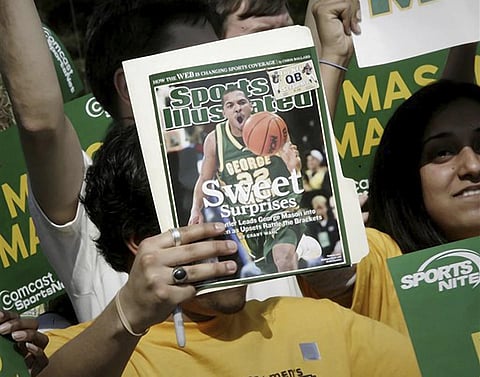 FILE - A George Mason University fan holds up a Sports Illustrated magazine at a send off for the team, March 29, 2006. (Photo | AP)