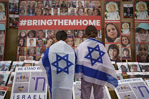Children look at photographs of Israelis kidnapped by Hamas during a rally joined by hundreds in solidarity with Israel and those held hostage in Gaza. (Photo | AP)