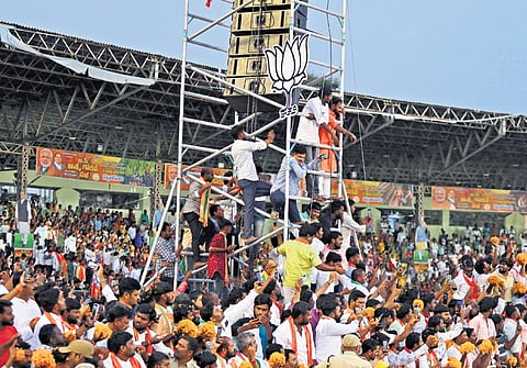 BJP supporters climb a post to catch a glimpse of Prime Minister Narendra Modi at the LB Stadium in Hyderabad on Tuesday | Sri Loganathan Velmurugan