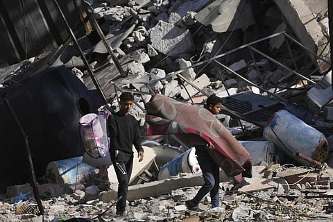 Palestinians visit their houses destroyed in the Israeli bombings. (Photo | AP)