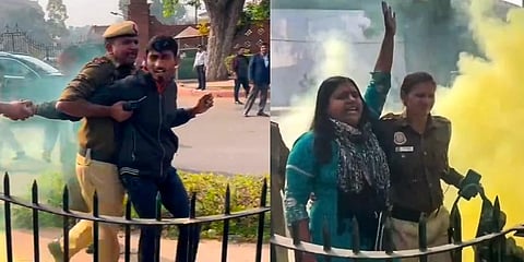 Police personnel apprehend two persons carrying a can emitting yellowish smoke while he was protesting outside the Parliament premises, during the Winter session, in New Delhi. (Photo | PTI)