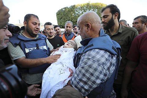 FILE - Al-Jazeera correspondent Wael al-Dahdouh holds his grandson killed in an Israeli airstrike. (Photo | AP)