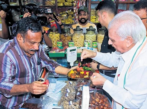 Governor Arif Mohammed Khan tasting halwa at SM Street in Kozhikode.
