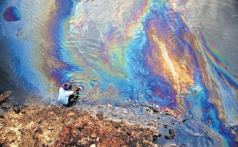 A fisherman seen washing his hands at the Ennore creek amid an oil spill after the cyclone hit Chennai (Photo | P. Ravikumar, EPS)