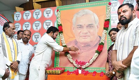 BJP state president G Kishan Reddy pays floral tributes to former prime minister Atal Bihari Vajpayee at the party office at Nampally in Hyderabad on Monday
