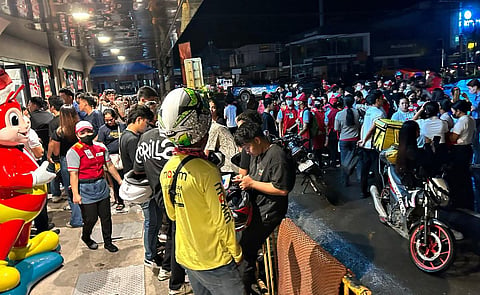 People gather along a street after evacuating from inside buildings after a 7.6 earthequake struck Butuan City, in southern island of Mindanao late December 2, 2023. (Photo | AFP)