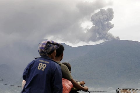 Motorists ride past by as Mount Marapi spews volcanic materials during its eruption in Agam, West Sumatara, Monday, Dec 4, 2023. (Photo / AP)