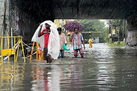 People walk through inundated roads in Nolambur, following the aftermath of cyclone Michuang in Chennai, on Monday. (Photo | Sunish P Surendran, EPS)
