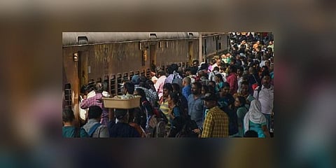 Sight of people bustling for space inside the train’s jam-packed coaches has become common