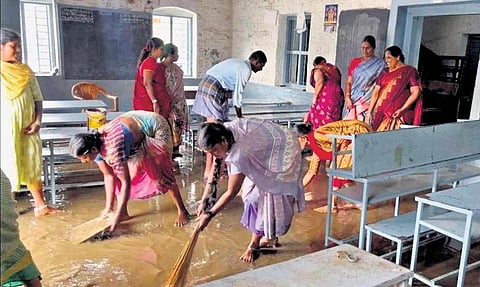 Workers clearing rain water from a classroom in a school at Thimmampalayam | Express
