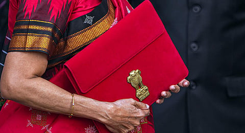 Union Finance Minister Nirmala Sitharaman carrying a folder-case poses for photographs outside the Finance Ministry. (Photo | PTI)