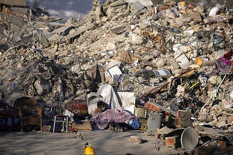 A man sleeps in front of a destroyed building in Kahramanmaras, southeastern Turkey.(Photo | AP)
