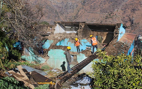 Workers demolish a building in the land subsidence-affected area in Joshimath, Saturday. (Photo | PTI)