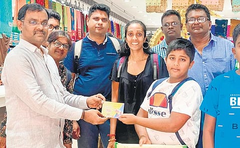 A shopkeeper issuing prize coupons to customers during Puducherry Shopping Festival in Karaikal on Wednesday | Express