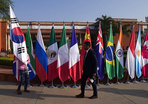 A worker carries flags of participating countries to be placed at the opening session of the G20 foreign ministers meeting, in New Delhi, India on Thursday, March 2, 2023. (Photo |AP0