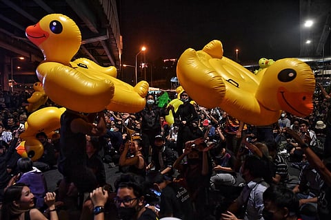 Protesters hold up large inflatable yellow ducks, which have become a symbol of the demonstrations, during an anti-government rally in Bangkok. (Photo | AFP)