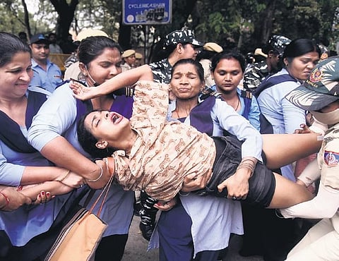 Police detain a protestor at Delhi University in New Delhi on Friday. (Photo| PTI)