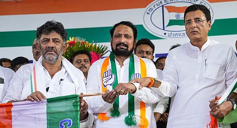 DK Shivakumar gives the party flag to former Karnataka deputy CM Laxman Savadi as the latter joins Congress ahead of Karnataka Assembly polls, at the KPCC office.(Photo | PTI)