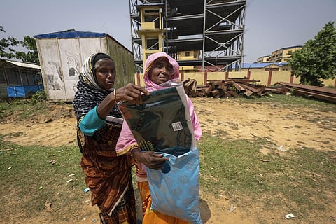 Asiya Khatoon (R), carrying a T-shirt, trousers and a cap for her husband Abul Kalam, cries as she walks towards his detention center in Assam's Matiya village, April 17, 2023. (Photo | AP)