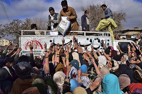 People jostle each other to buy subsidized sacks of wheat flour in Quetta, Pakistan, Thursday, Jan. 12, 2023, after a recent price hike of flour in the country. (Photo | AP)