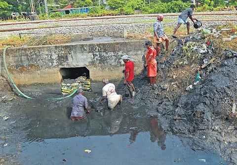 Tamil migrant labourers clean a canal without any safety gear near Kathrikadavu bridge