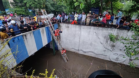 Emergency personnel rescue a family of six who were trapped in the flooded KR Circle underpass in Bengaluru on Sunday. One member of the family passed away later. (Photo | Nagaraja Gadekal, EPS)