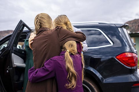 FILE - Three girls embrace before they are removed from the home of Samuel Bateman, following his arrest in Colorado City, Ariz., on Sept. 14, 2022. (Photo | AP)