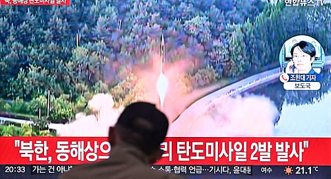 A man watches a television showing a news broadcast with file footage of a North Korean missile test. (Photp | AFP)