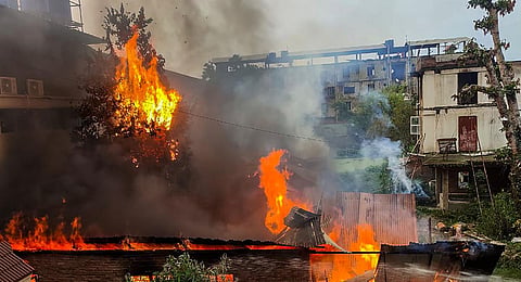 Flames and smoke billow out after an old warehouse owned by a retired bureaucrat was set ablaze amid violence in Manipur