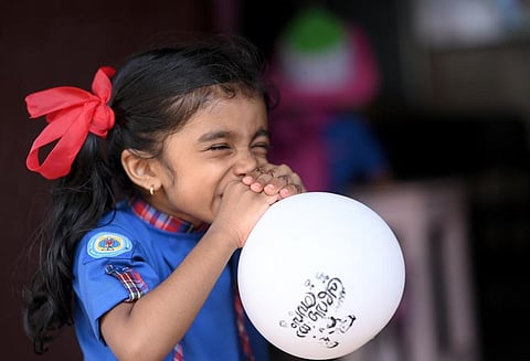 A girl blowing up the balloon on school reopening day at BEM L P school Mananchira.(Photo | EPS/ E Gokul)