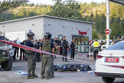 Israeli police stand next to the body of a Palestinian gunman at the scene of a shooting attack near the West Bank Israeli settlement of Eli, Tuesday, June 20, 2023. (Photo | AP)