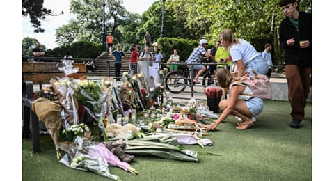 People lay flowers and candles for the victims of the stabbing attack. (Photo | AFP)