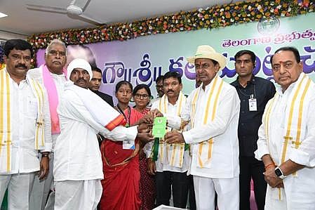 Chief Minister Chandrasekhar Rao hands over patta to a podu farmer in Asifabad on Friday.