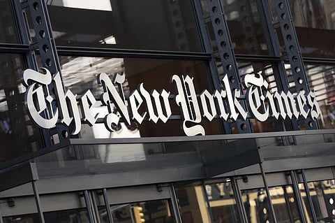 A sign for The New York Times hangs above the entrance to its building