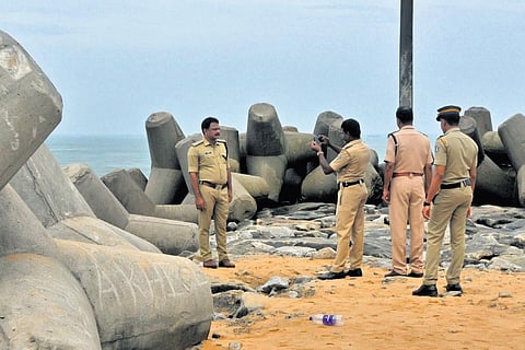 Police officials taking a photograph of their senior officer who is in charge of the rescue mission of the missing fisherman at Muthalapozhi. ( Photo | B P Deepu)