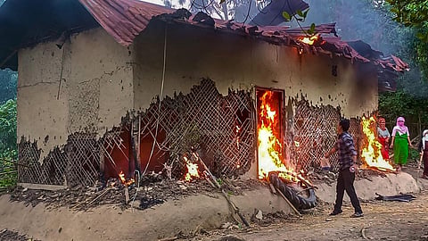 People set ablaze the house of Manipur sexual assault case accused, in Tuinomkhopi, Manipur, Friday. (Photo | PTI)