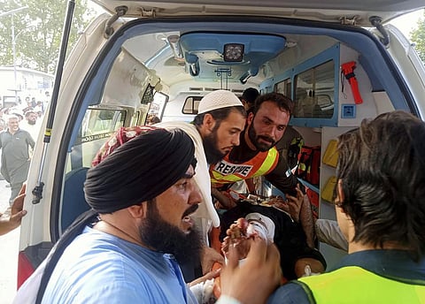 rescue workers carry a wounded man after a bomb explosion in the Bajur district of Khyber Pakhtunkhwa, Pakistan. (Photo | AP)