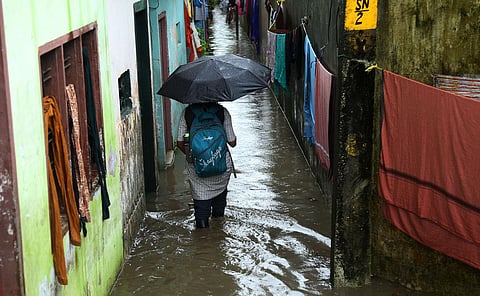 Children and their parents wading through a waterlogged street at P&T Colony in Kochi following the heavy rain. (Photo | T P Sooraj, EPS)