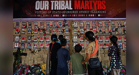 FILE - People look at portraits of victims who lost their lives during ethnic clashes, at a memorial in Churachandpur district in Manipur, July 24, 2023. (Photo | AFP)