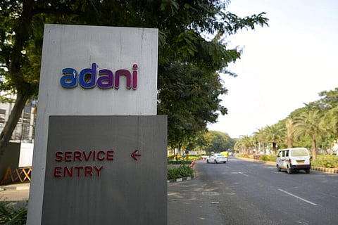 FILE - Vehicles move past a signage near the entrance of Adani Corporate House in Ahmedabad, India. (Photo | AP)