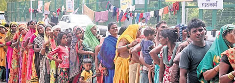 Flood victims stand in a queue to get food items at a relief camp in Mayur Vihar .| Parveen Negi