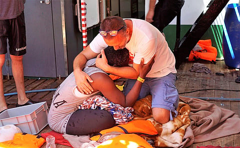 FILE-In this representational image, a migrant is comforted by a crew member of the Open Arms Spanish humanitarian boat off the coast of the Sicilian island of Lampedusa, southern Italy. (Photo | AP)