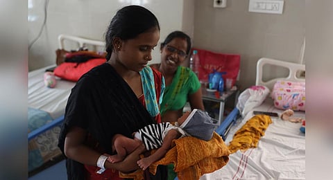 Meena, who underwent a C-section delivery at the King Koti Hospital in Hyderabad, holds her newborn on Monday. (Photo | Sri Loganathan Velmurugan)